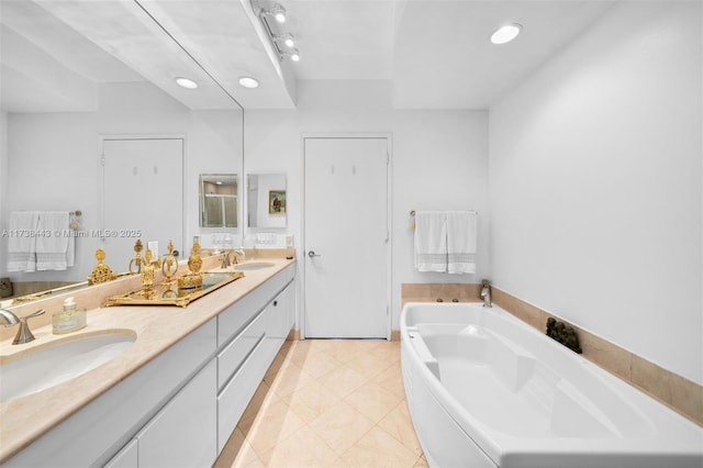 bathroom featuring vanity, a bath, and tile patterned floors