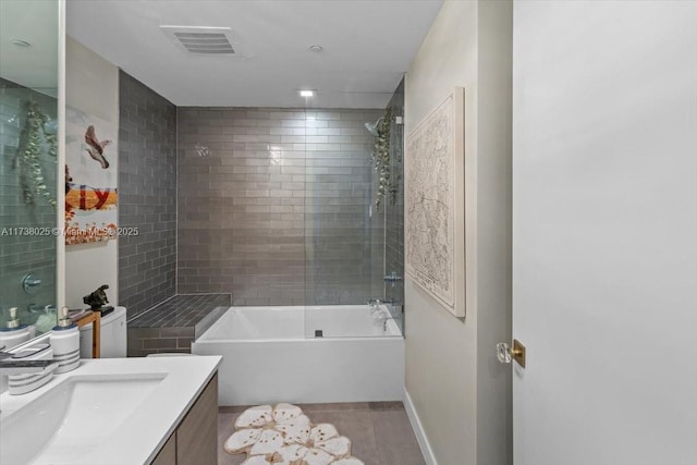 bathroom featuring vanity and tiled shower / bath