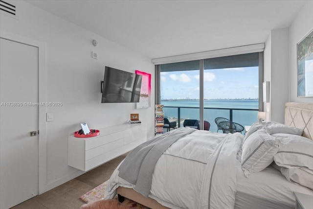 bedroom featuring access to exterior and a wall of windows