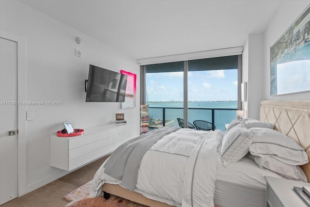 bedroom featuring access to exterior, wood-type flooring, and expansive windows