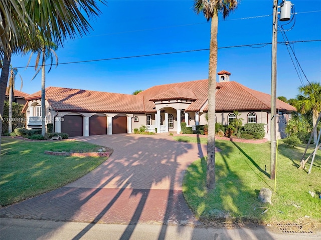 mediterranean / spanish home with a garage and a front yard