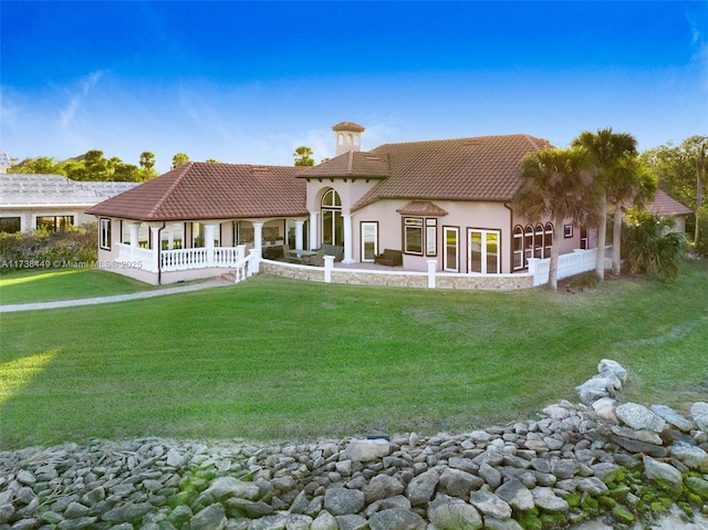 rear view of property featuring a lawn