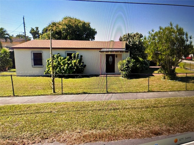 ranch-style home with a front lawn and a fenced front yard