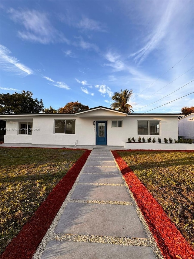 single story home featuring a front lawn