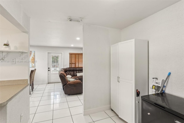 interior space featuring light tile patterned flooring and white cabinets