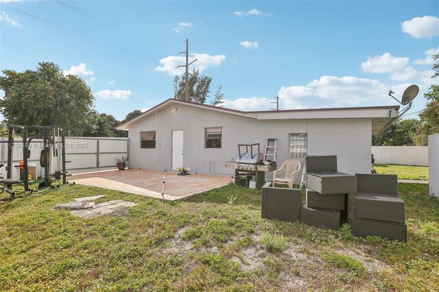 rear view of house featuring a yard and a patio