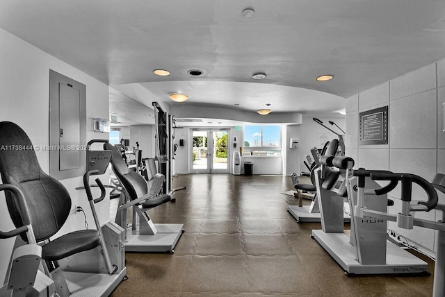 gym featuring tile walls and french doors