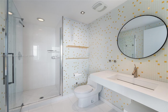 bathroom with tile patterned flooring, a shower with door, sink, and toilet