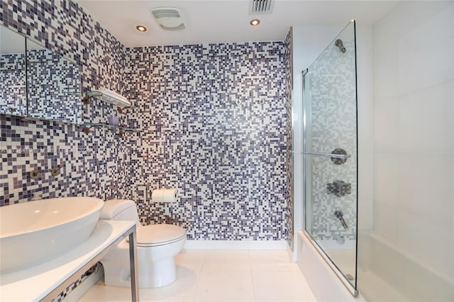 bathroom with walk in shower, toilet, tile patterned flooring, and tile walls