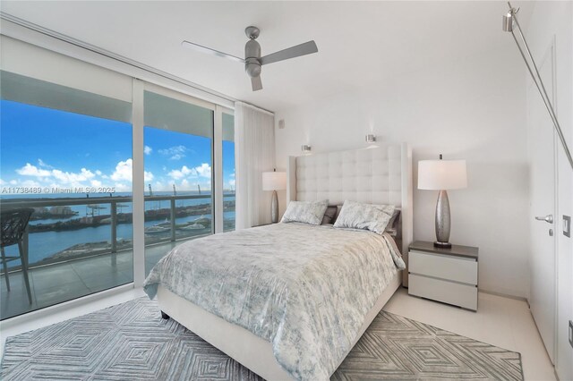 450 Alton Rd Unit 3401, Miami Beach, FL 33139 - tiled bedroom featuring access to exterior, expansive windows, a water view, and a ceiling fan