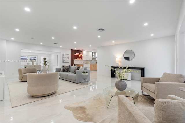 living area featuring recessed lighting and light marble finish floors