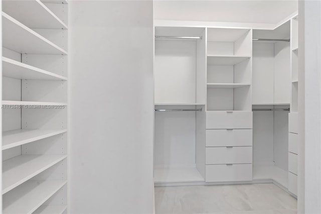 walk in closet with light marble finish floors