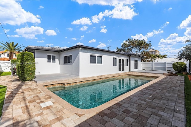 back of property featuring a fenced in pool and a patio area