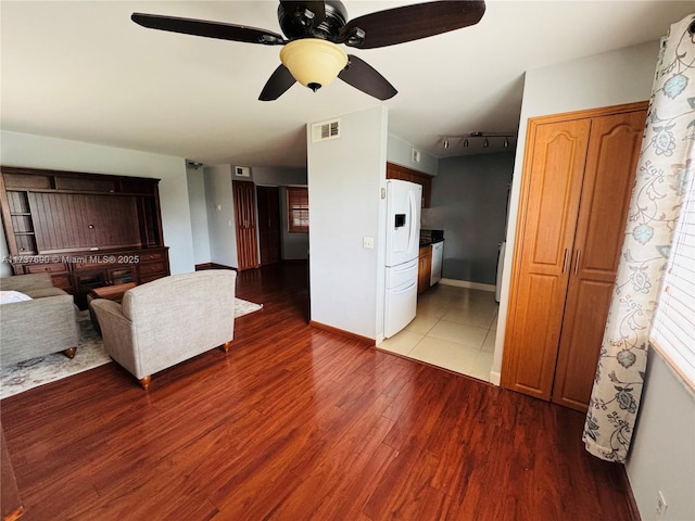 unfurnished living room with visible vents, ceiling fan, baseboards, and wood finished floors