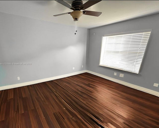 unfurnished room featuring ceiling fan, dark wood-style flooring, and baseboards