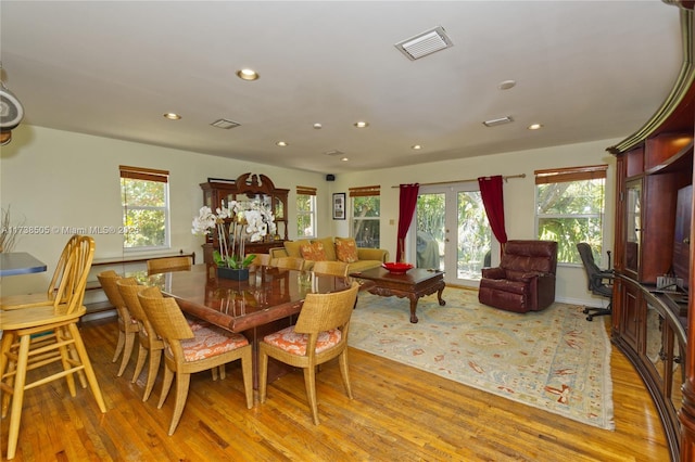 dining area with plenty of natural light, light hardwood / wood-style floors, and french doors