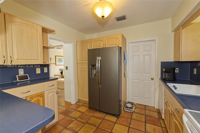 kitchen with stainless steel refrigerator with ice dispenser, sink, light brown cabinets, dishwasher, and stove