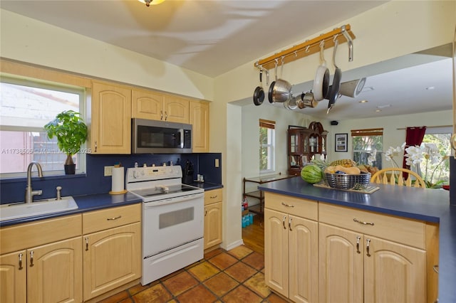 kitchen with a wealth of natural light, sink, white electric range, and light brown cabinetry