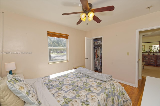 bedroom featuring ceiling fan, light wood-type flooring, and a closet