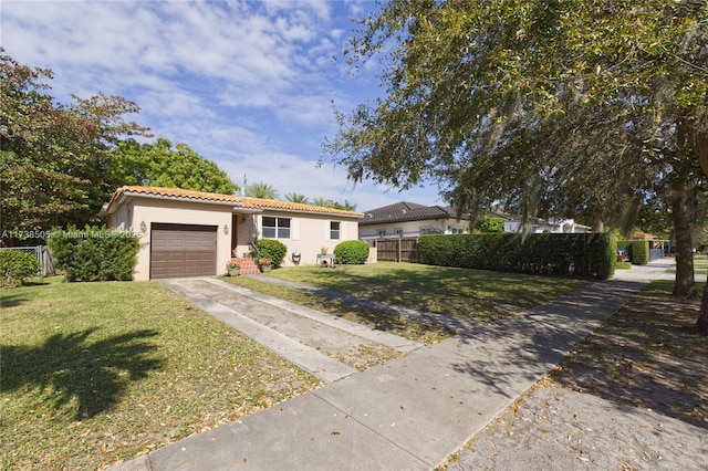 view of front of home with a garage and a front lawn