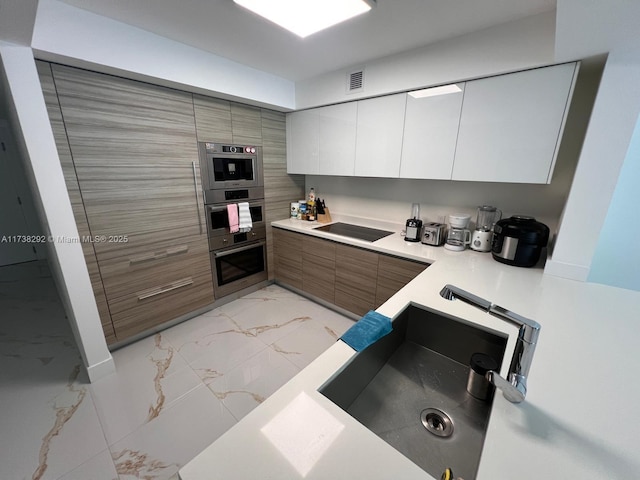 kitchen featuring black electric cooktop, white cabinetry, stainless steel double oven, and sink