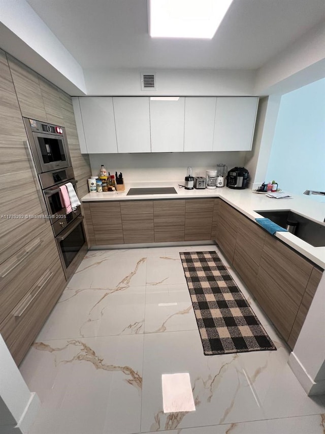 kitchen featuring white cabinetry, sink, and black electric cooktop