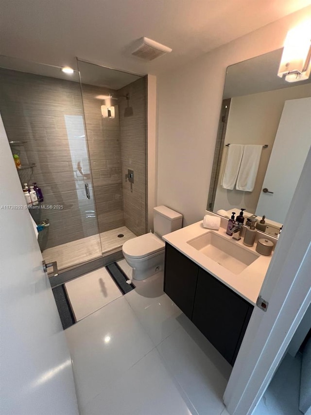 bathroom featuring tile patterned floors, vanity, toilet, and an enclosed shower