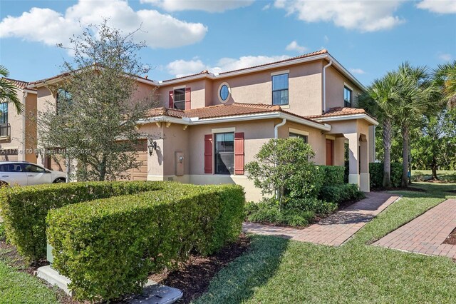 mediterranean / spanish-style home with a front lawn