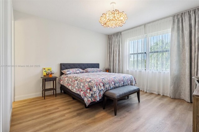 bedroom featuring hardwood / wood-style flooring and a notable chandelier