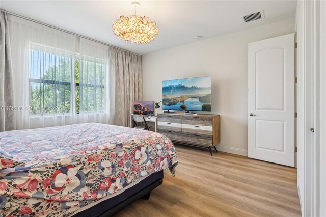 bedroom with a notable chandelier and wood-type flooring