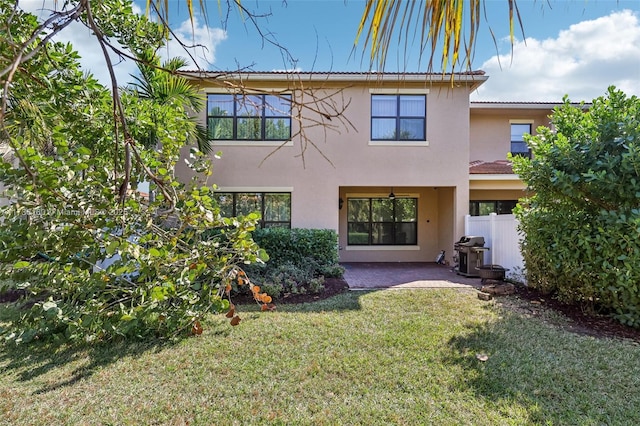 back of property featuring a patio and a lawn