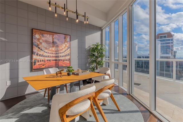 dining room with expansive windows, dark wood-type flooring, and tile walls