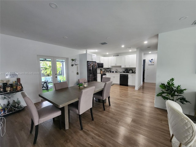 dining space with french doors and wood-type flooring