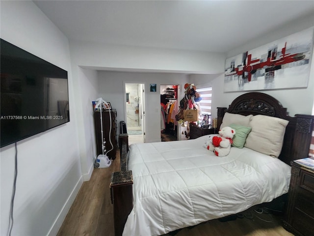 bedroom with hardwood / wood-style flooring and connected bathroom