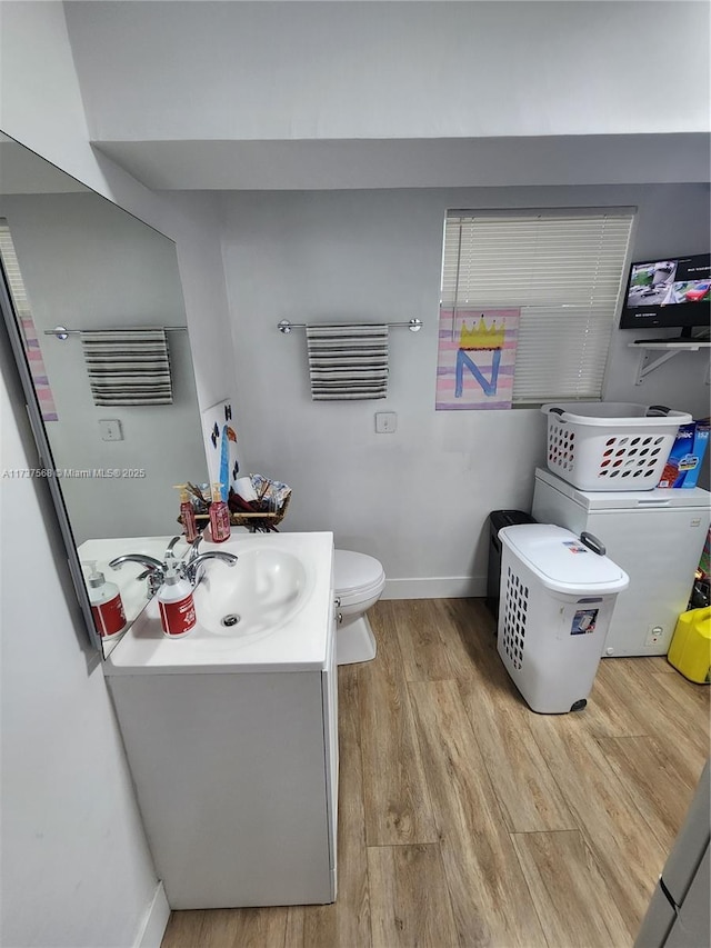 bathroom with vanity, toilet, and wood-type flooring