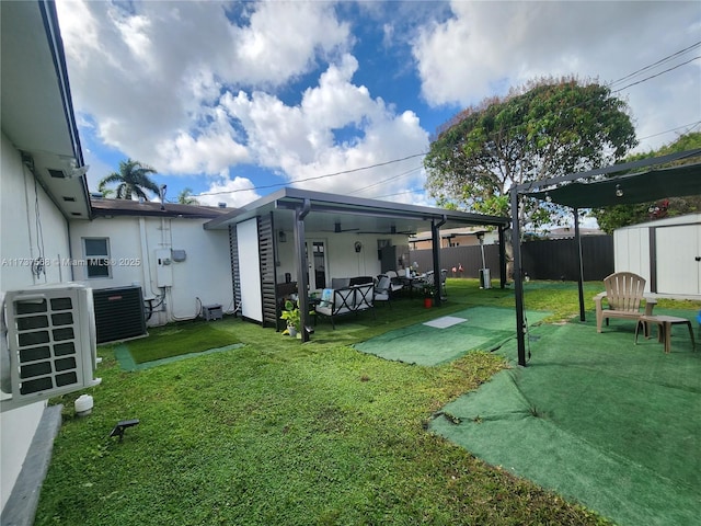 view of yard featuring central AC unit, outdoor lounge area, a patio, a shed, and ac unit