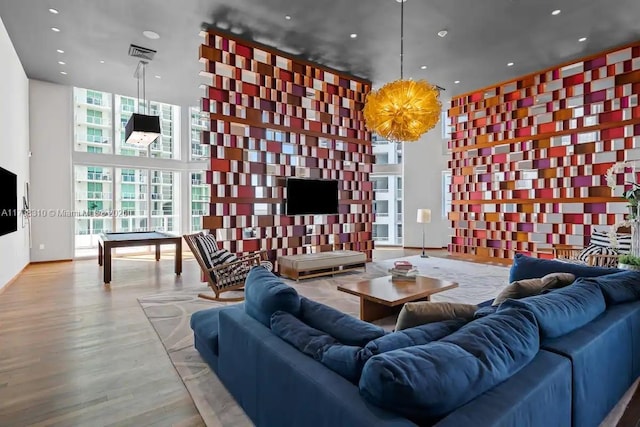 living room featuring expansive windows, a towering ceiling, and light wood-type flooring