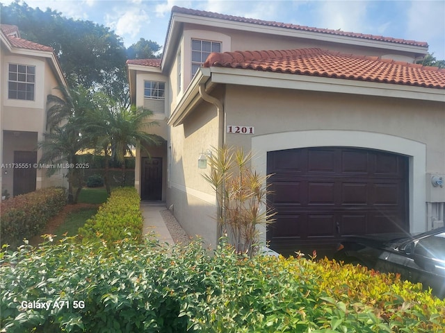 view of front of property featuring an attached garage and stucco siding