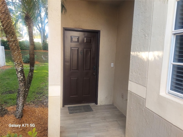 entrance to property featuring stucco siding