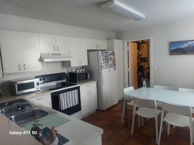 kitchen with range with electric cooktop, stainless steel microwave, freestanding refrigerator, under cabinet range hood, and a sink