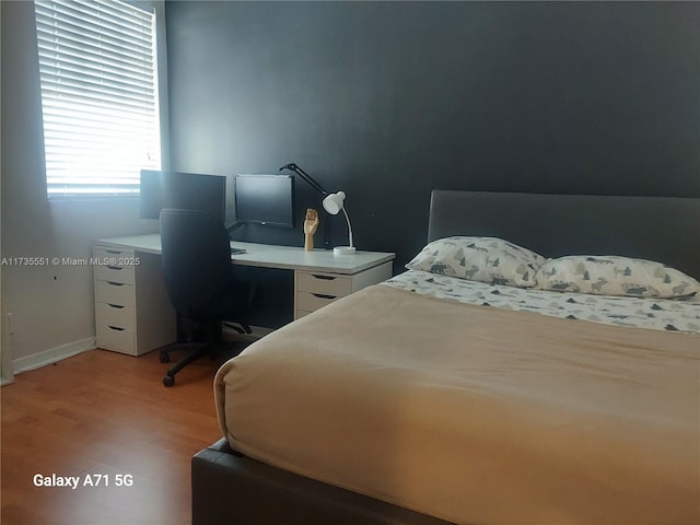 bedroom with baseboards and light wood finished floors