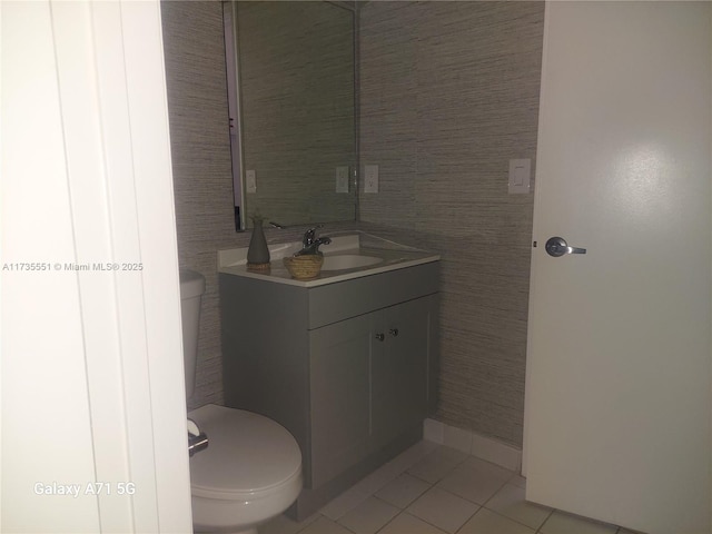 bathroom featuring toilet, tile patterned floors, tile walls, and vanity