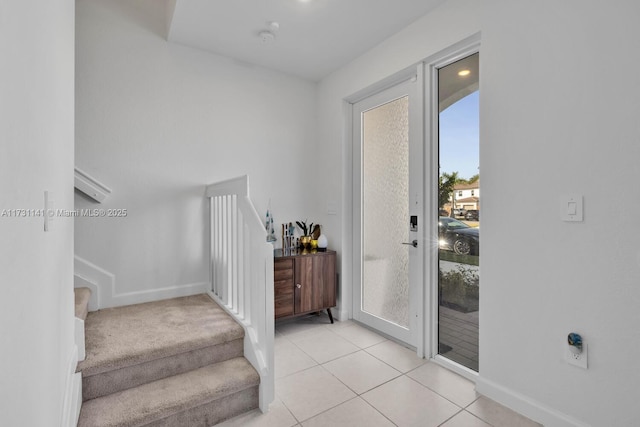 doorway to outside with light tile patterned floors