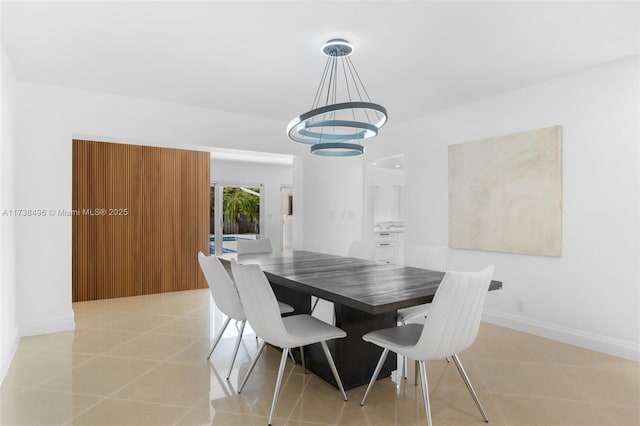 tiled dining space featuring a notable chandelier