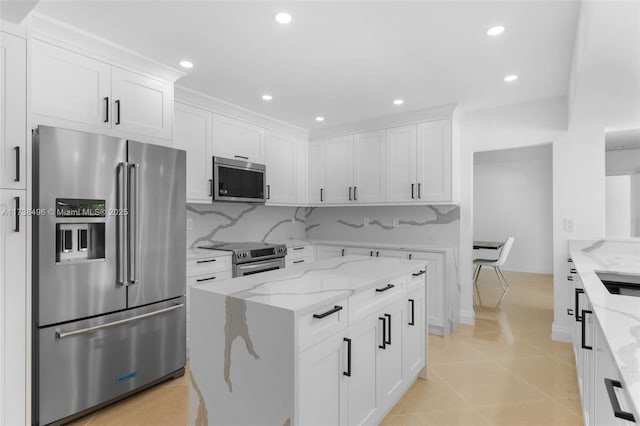 kitchen with white cabinetry, appliances with stainless steel finishes, and light stone counters