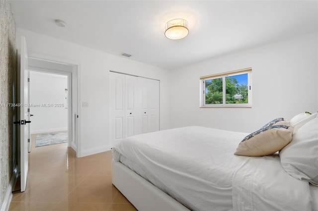 tiled bedroom with a closet