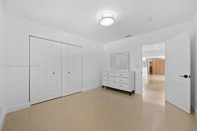 unfurnished bedroom featuring light tile patterned flooring and a closet