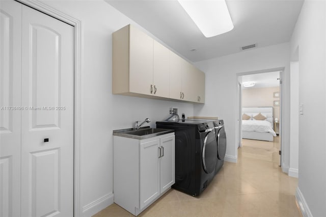 laundry area featuring cabinets, sink, washer and dryer, and light tile patterned floors