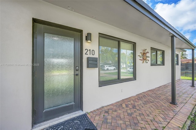 property entrance with stucco siding