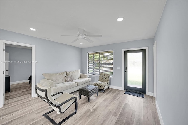 living room with ceiling fan and light hardwood / wood-style flooring